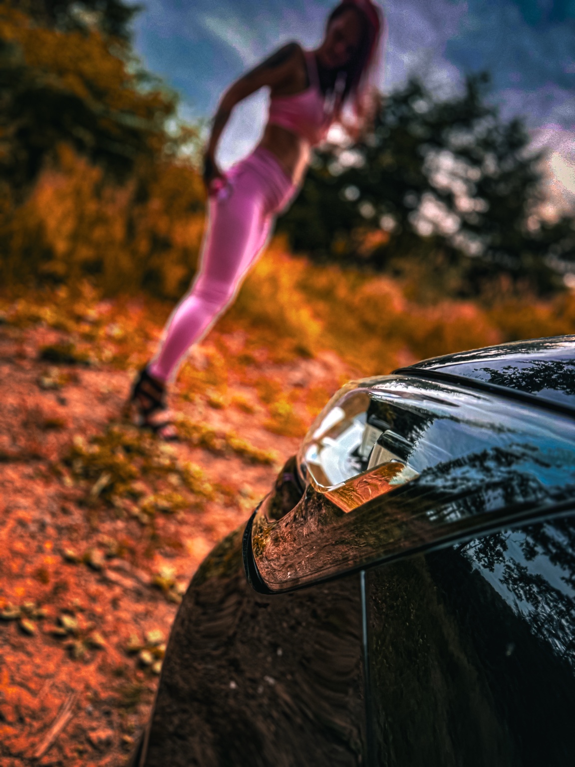 Inszenierte Autodetails mit rosa Outfit im Hintergrund