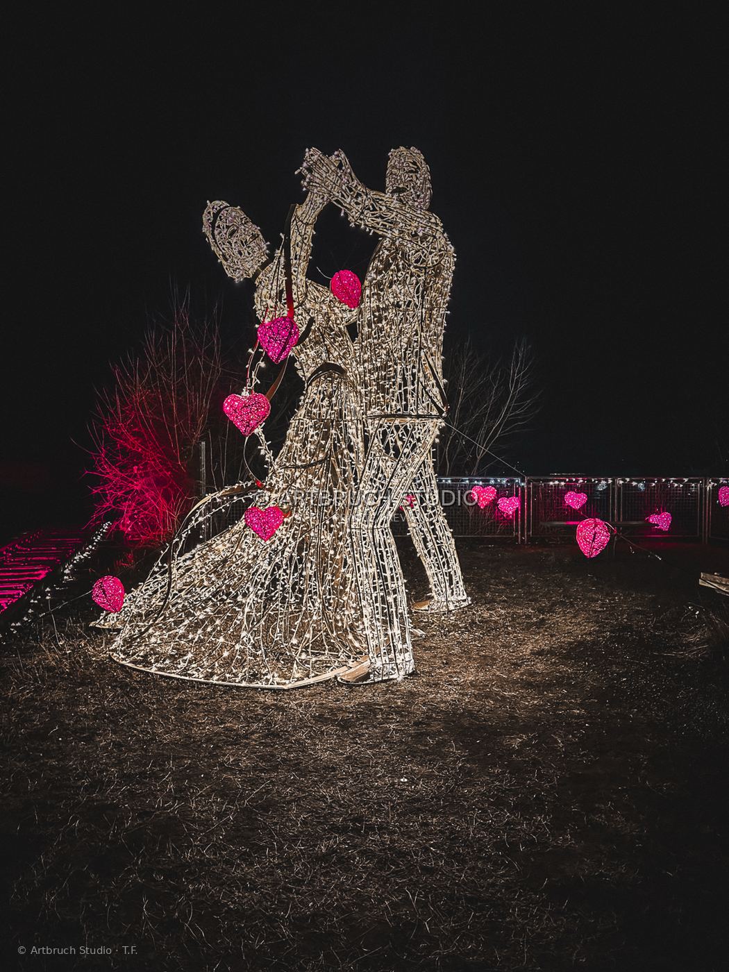 Leuchtende Figuren mit roten Herzen bei Nacht